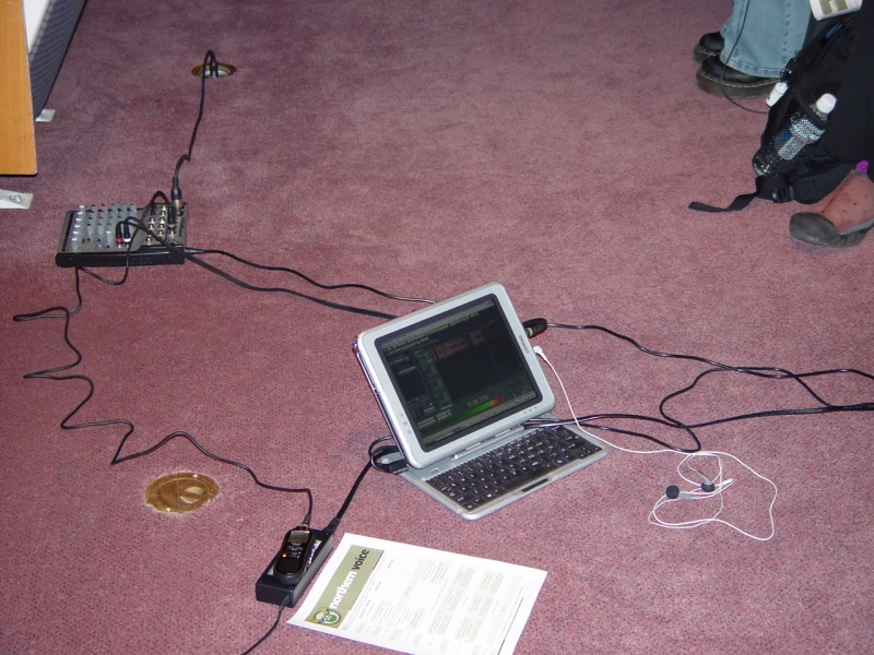 A podcasting recording setup with microphones and laptop